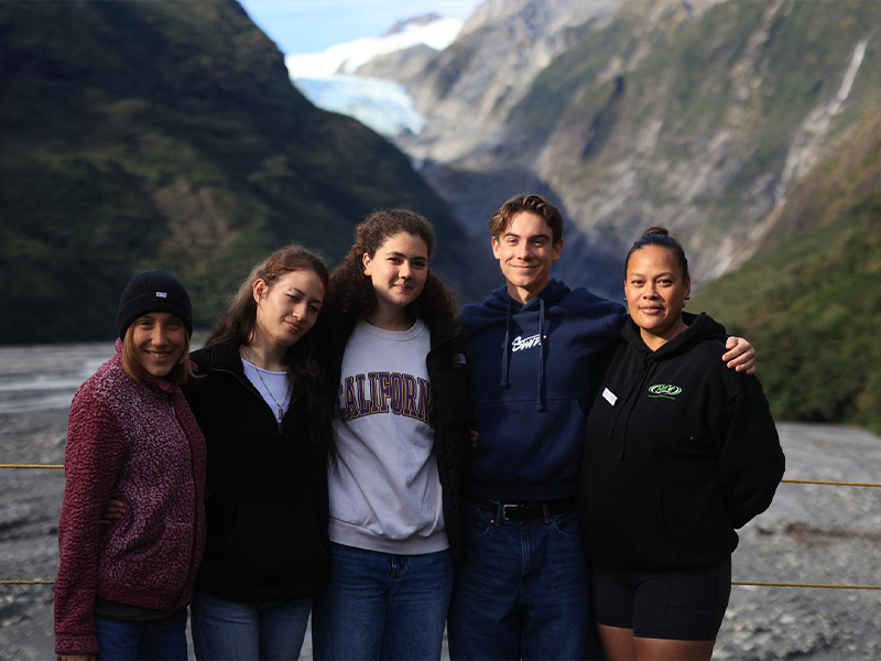 Nuova Zelanda  Gli studenti possono scegliere la scuola tra una selezione di High School, garantendo un’esperienza accademica di qualità e una piena immersione nella vita scolastica locale. Saranno ospitati in famiglie accuratamente selezionate e vivranno la quotidianità dei coetanei neozelandesi, praticando la lingua ogni giorno e costruendo legami autentici con compagni e host. Il programma segue la struttura dei trimestri scolastici neozelandesi: Term 1: da fine gennaio/inizio febbraio a inizio aprile Term 2: da fine aprile a inizio luglio Term 3: da metà luglio a fine settembre Term 4: da inizio ottobre a metà dicembre Le partenze sono possibili all'inizio di ciascun trimestre, offrendo flessibilità e la possibilità di inserirsi pienamente nel percorso educativo. Il programma rappresenta un’occasione unica per vivere la Nuova Zelanda da vicino, combinando studio, vita familiare e attività extracurriculari, e costituisce un primo passo ideale per chi desidera affrontare in futuro un anno scolastico all’estero, sviluppando competenze linguistiche e interculturali preziose. E’ obbligatorio l’uso della divisa. E per chi ama le attività all’aria aperta, è possibile scegliere scuole che offrono programmi specializzati di outdoor education, con esperienze pratiche e stimolanti pensate per favorire lo sviluppo personale e sociale. Tra lezioni a scuola, avventure nella natura e attività quotidiane, ogni giorno diventa un’occasione unica di crescita e scoperta: dal rafting sui maestosi fiumi, allo sci su piste di livello mondiale, fino al trekking tra spettacolari catene montuose. Studio e sistema scolastico in Nuova Zelanda La High School neozelandese copre generalmente gli anni dal Year 9 al Year 13, per studenti dai 13 ai 18 anni, ed è suddivisa così: Year 9-10 – Lower Secondary (13-15 anni) Year 11-13 – Upper Secondary / Senior School (15-18 anni) Nella high school neozelandese si studiano materie obbligatorie come inglese, matematica, scienze naturali, scienze sociali e educazione fisica, oltre a un numero limitato di materie a scelta che includono le arti, le lingue, le discipline tecniche e persino materie come la cucina o il design. Le scuole neozelandesi offrono anche attività extracurriculari, come sport, club che permettono di inserirsi nella vita scolastica locale e vivere pienamente la quotidianità con coetanei neozelandesi, praticare la lingua ogni giorno.